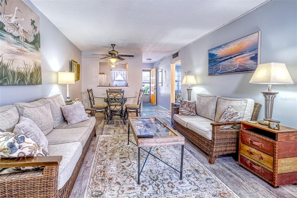 13714 Mission Oaks Boulevard, Unit 13714 Seminole, FL 33776 - Photo 8 of 24 a living room with furniture and a chandelier