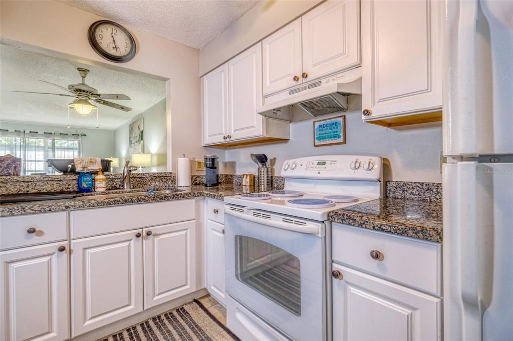 13714 Mission Oaks Boulevard, Unit 13714 Seminole, FL 33776 - Photo 9 of 24 a kitchen with cabinets appliances and a counter top space