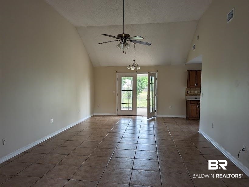 12971 Labradors Run Foley, AL 36535 - Photo 2 of 23 Expansive open-concept room featuring vaulted ceilings, neutral-toned walls, and large format tile flooring