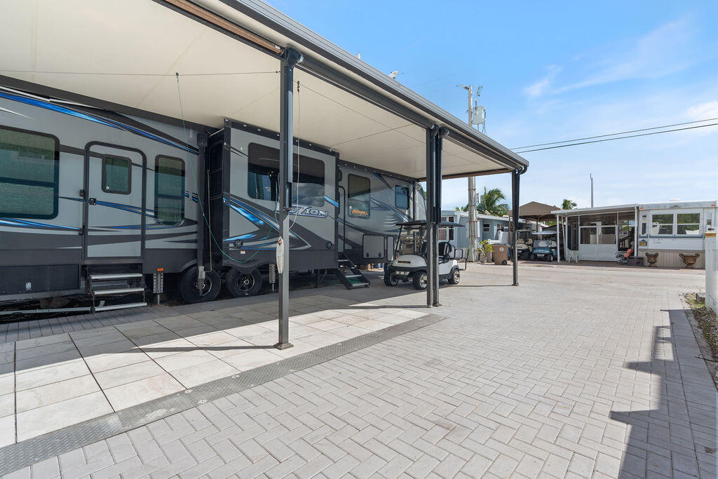 325 Calusa Street, Unit 351 Key Largo, FL 33037 - Photo 10 of 18 a view of a patio with table and chairs with wooden floor and fence