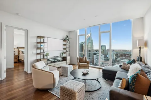 a living room with furniture wooden floor and a large window