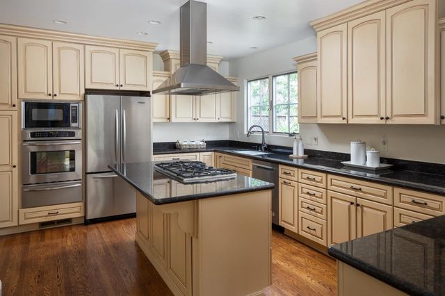 a kitchen with granite countertop a stove sink and refrigerator