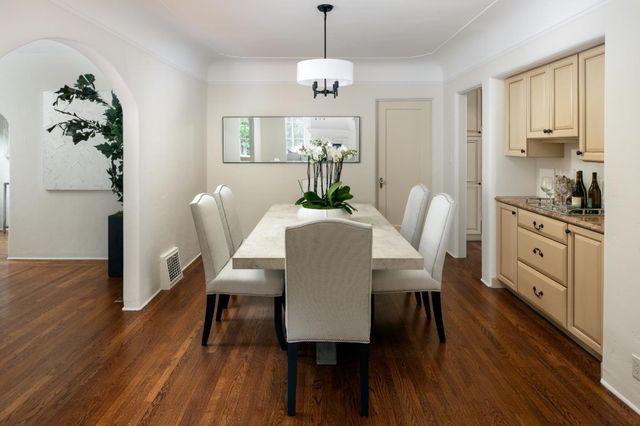 a dining room with furniture a chandelier and wooden floor