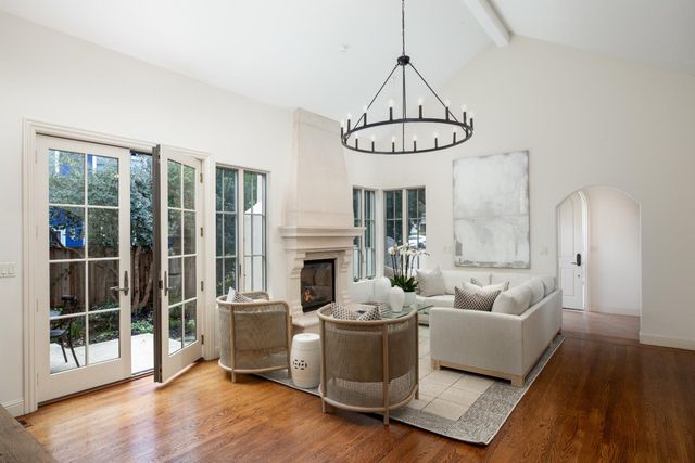 a living room with furniture a fireplace and a chandelier