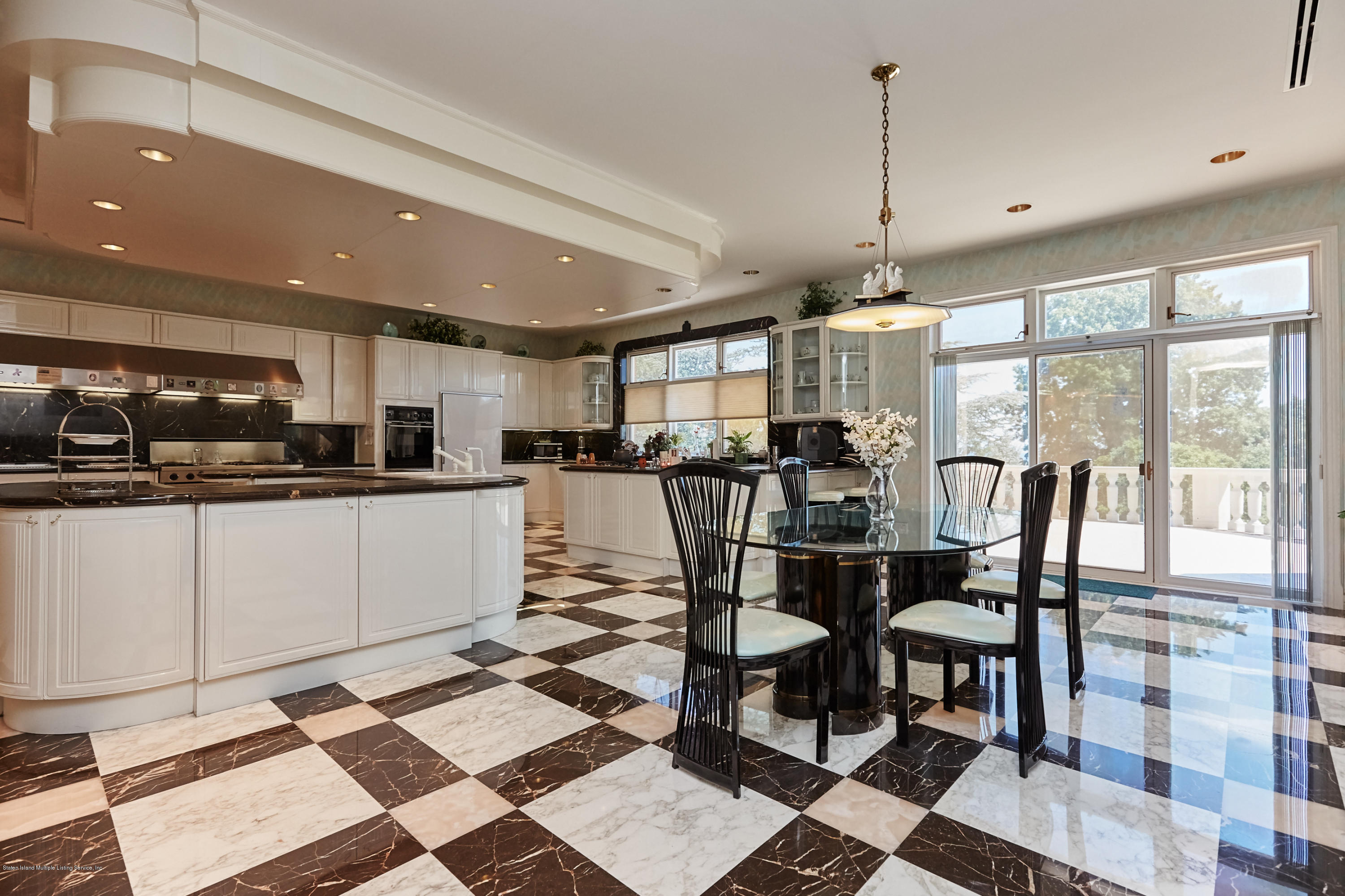 95 Circle Road Staten Island, NY 10304 - Photo 16 of 42 a kitchen with stainless steel appliances kitchen island granite countertop a stove a sink a dining table and chairs with wooden floor