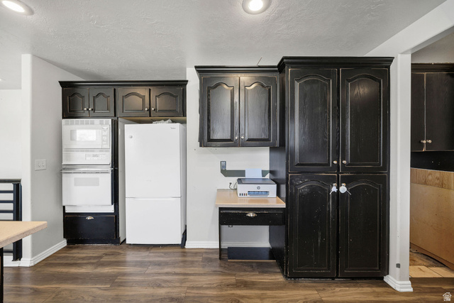 892 East 400 South Smithfield, UT 84335 - Photo 13 of 44 Kitchen featuring white appliances, dark wood-style flooring, and dark cabinetry