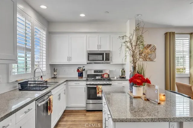 a kitchen with stainless steel appliances granite countertop a sink stove and cabinets