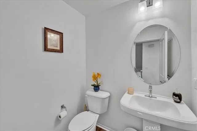 a bathroom with a toilet a sink and mirror