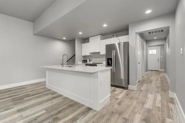 a kitchen with stainless steel appliances a refrigerator sink and cabinets