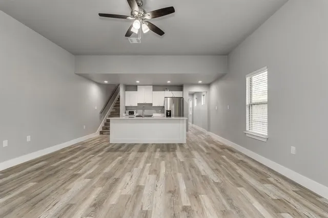 a view of a big room with wooden floor and windows