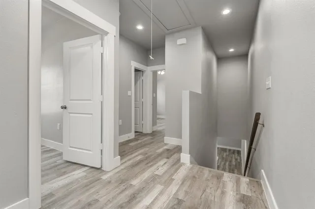 a view of a hallway with wooden floor and staircase