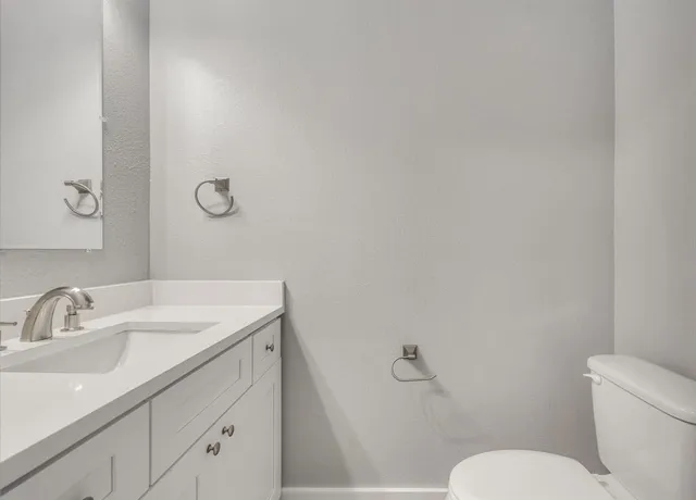 a bathroom with a sink and mirror with toilet