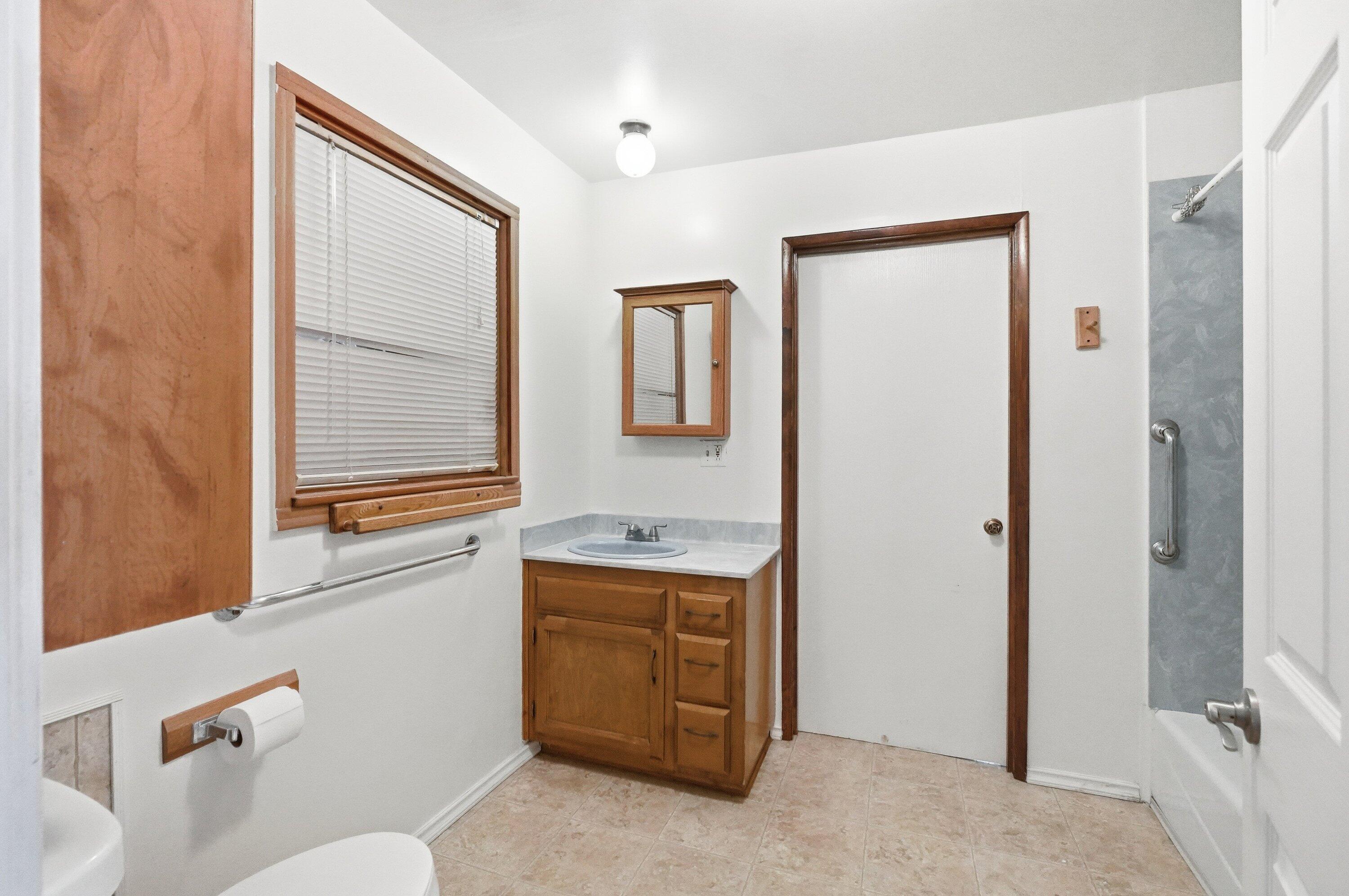 827 Summit Loop Grants Pass, OR 97527 - Photo 13 of 32 a bathroom with a granite countertop sink a toilet and a mirror