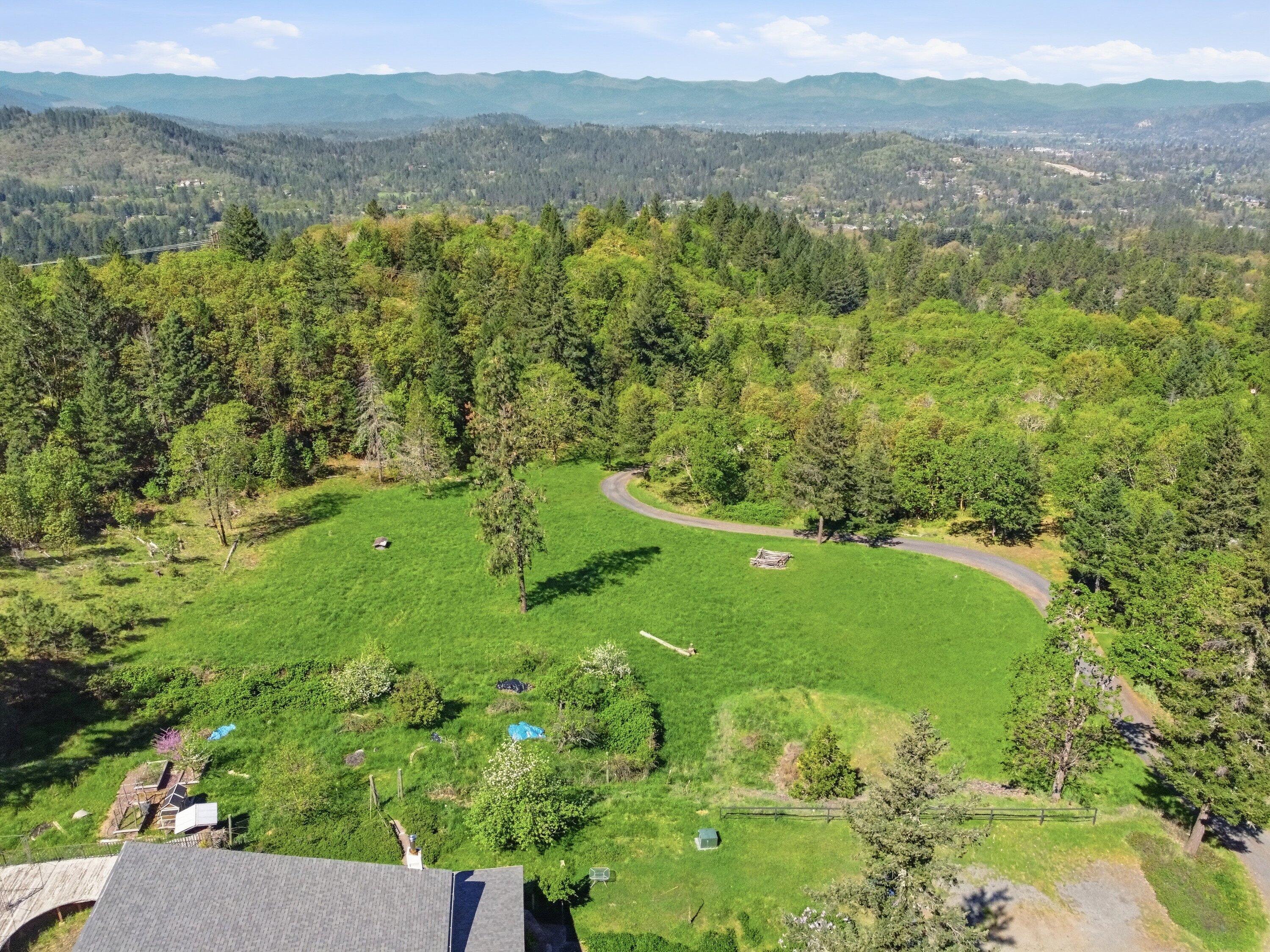 827 Summit Loop Grants Pass, OR 97527 - Photo 29 of 32 a view of a lush green forest with trees and some houses