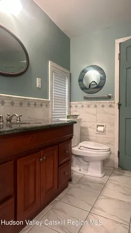 a bathroom with a toilet a sink and a mirror