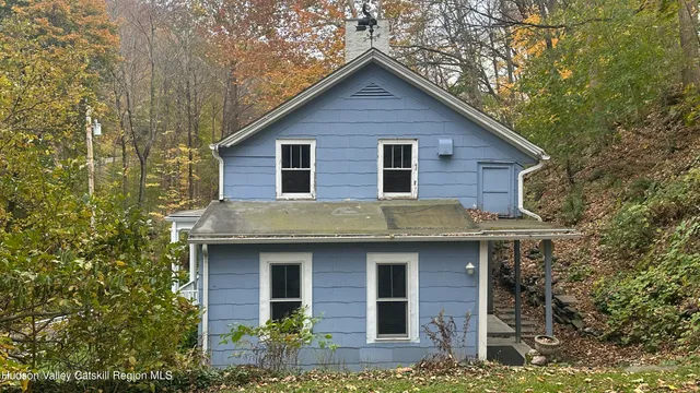 a front view of a house with yard and trees