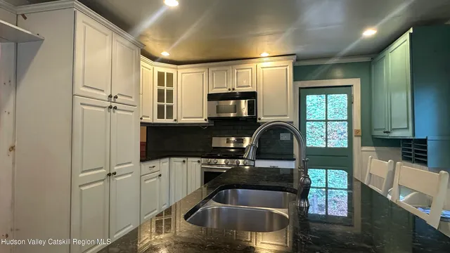 a kitchen with granite countertop a sink and a refrigerator