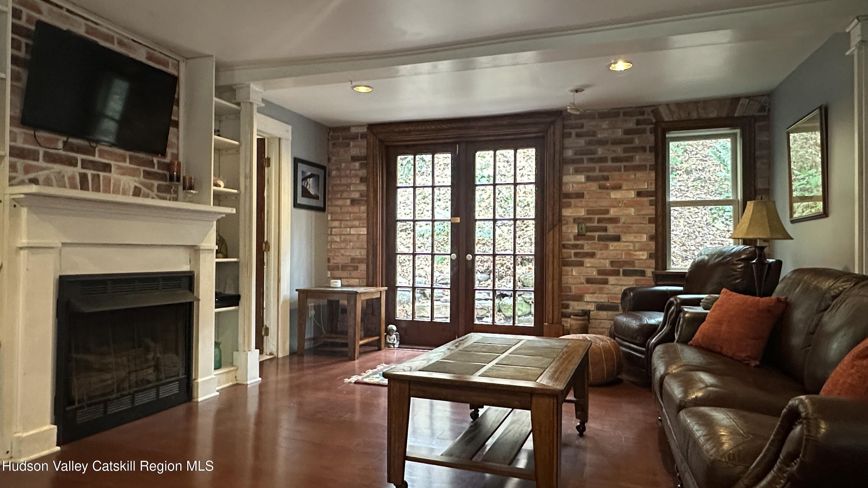 7 River Road, Unit TOWN ROAD Highland, NY 12528 - Photo 7 of 25 a living room with furniture a flat screen tv and a fireplace