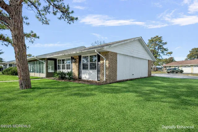 a view of a house with a big yard and large trees