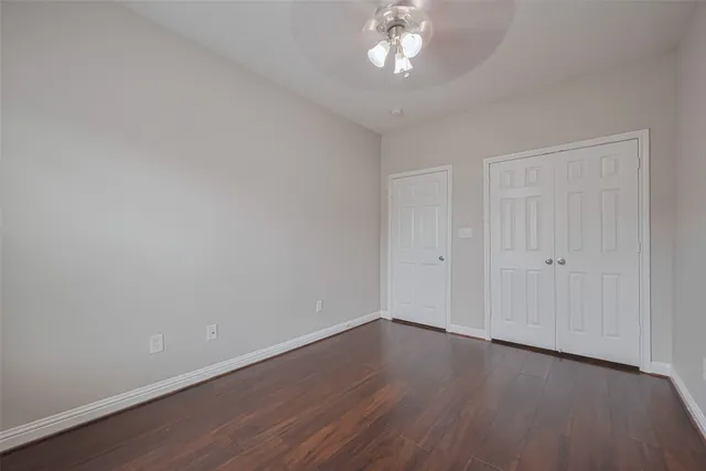 a view of a room with wooden floor and chandelier fan
