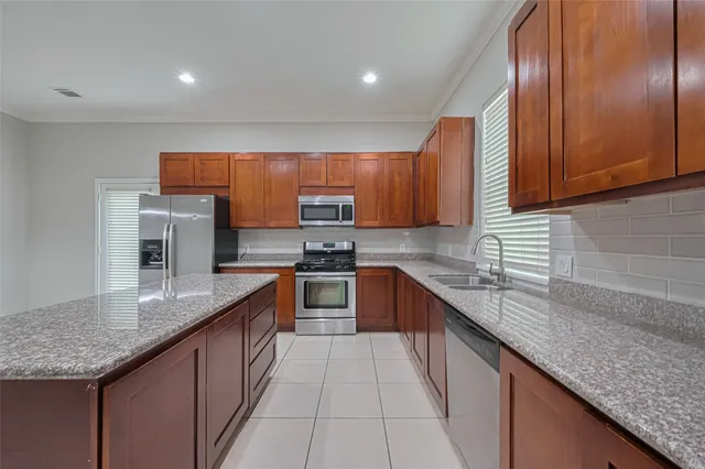 a kitchen with stainless steel appliances granite countertop wooden cabinets a sink and dishwasher