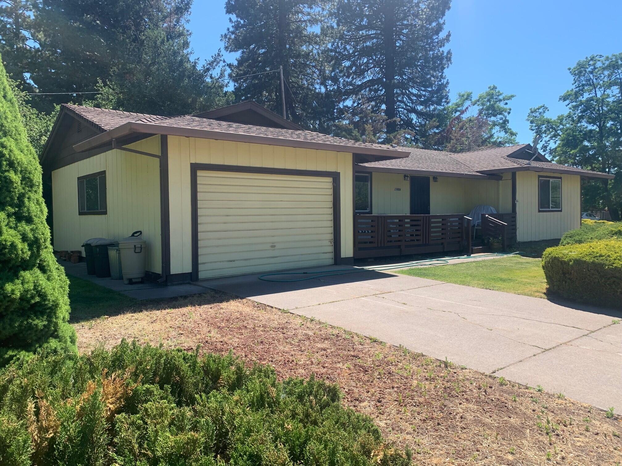 20604 Roff Way Burney, CA 96013 - Photo 29 of 32 a front view of a house with a yard and garage