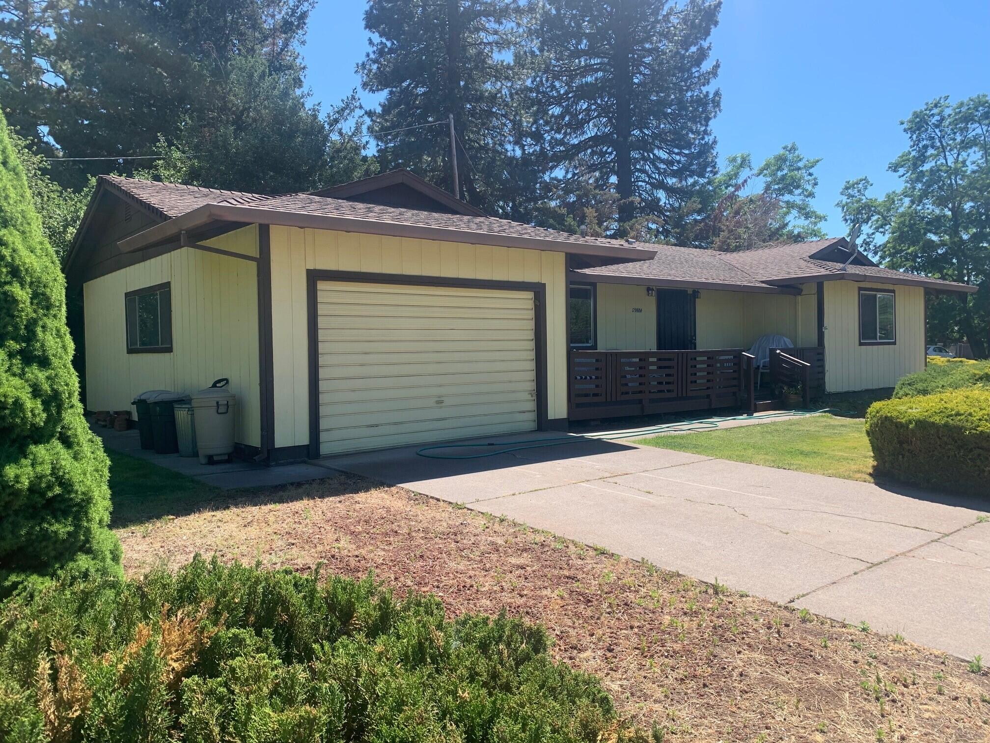 20604 Roff Way Burney, CA 96013 - Photo 30 of 32 a front view of a house with a yard and garage