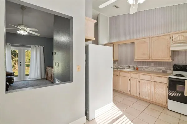 a kitchen with granite countertop a refrigerator a sink and dishwasher