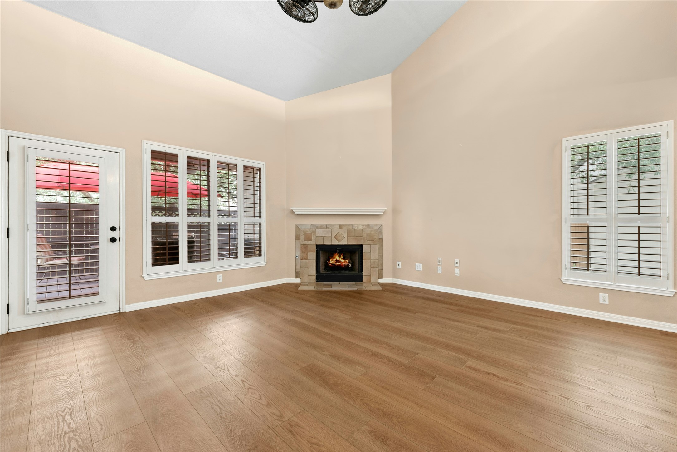 7500 Shadowridge Run, Unit 34 Austin, TX 78749 - Photo 9 of 27 a view of an empty room with wooden floor fireplace and a window