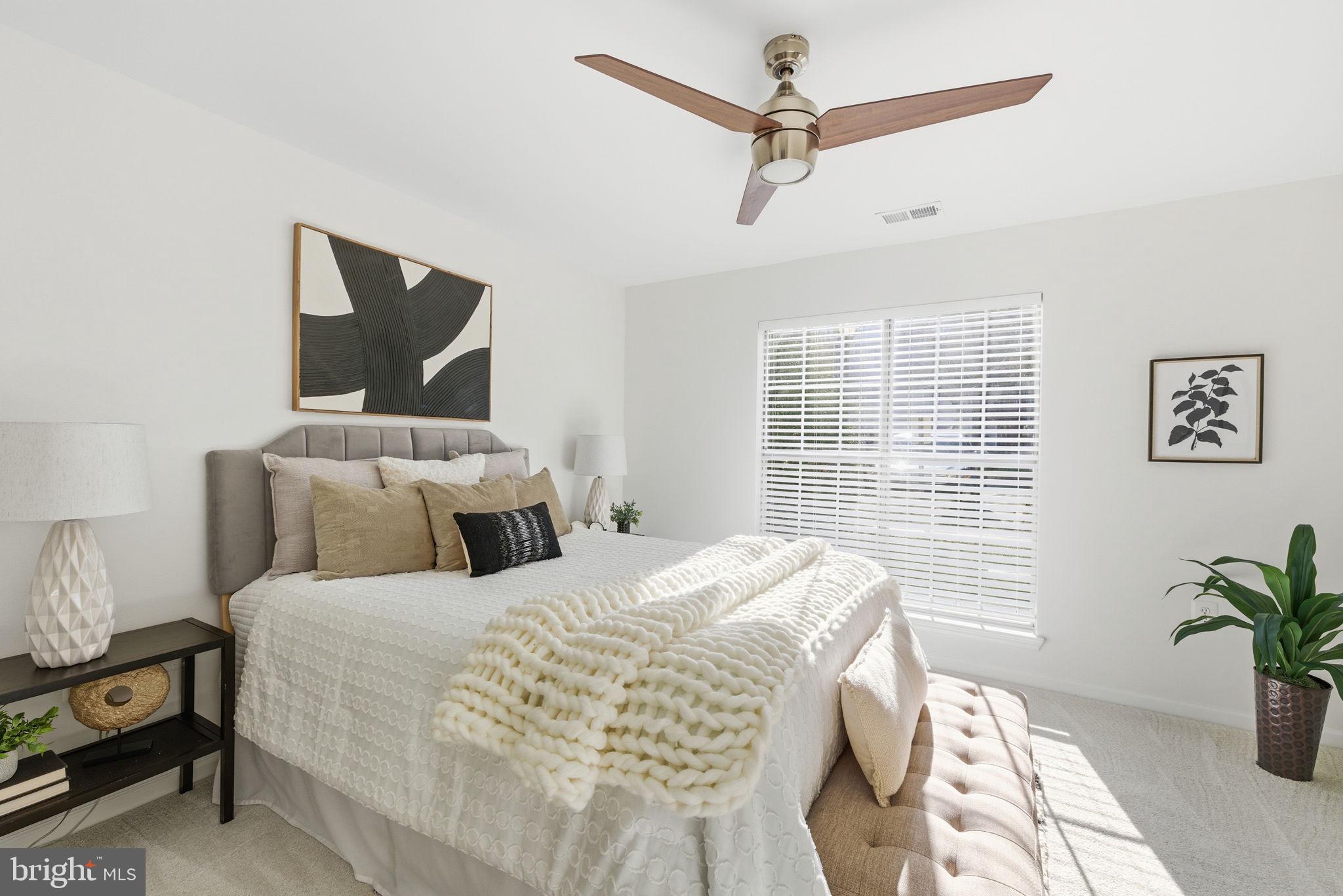 20963 Timber Ridge Terrace, Unit 103 Ashburn, VA 20147 - Photo 12 of 32 a bedroom with a large bed and a potted plant