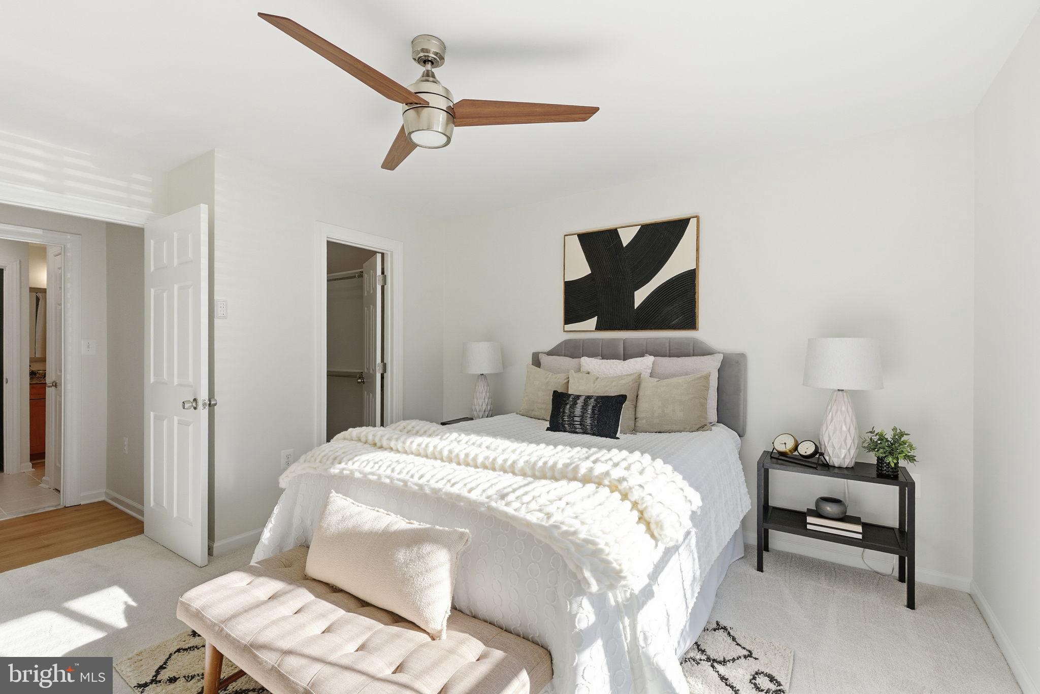 20963 Timber Ridge Terrace, Unit 103 Ashburn, VA 20147 - Photo 13 of 32 a bedroom with a bed and wooden floor