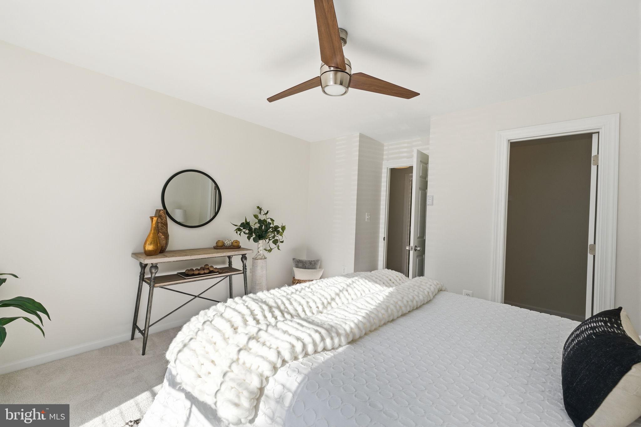 20963 Timber Ridge Terrace, Unit 103 Ashburn, VA 20147 - Photo 14 of 32 a bedroom with a bed and cabinets