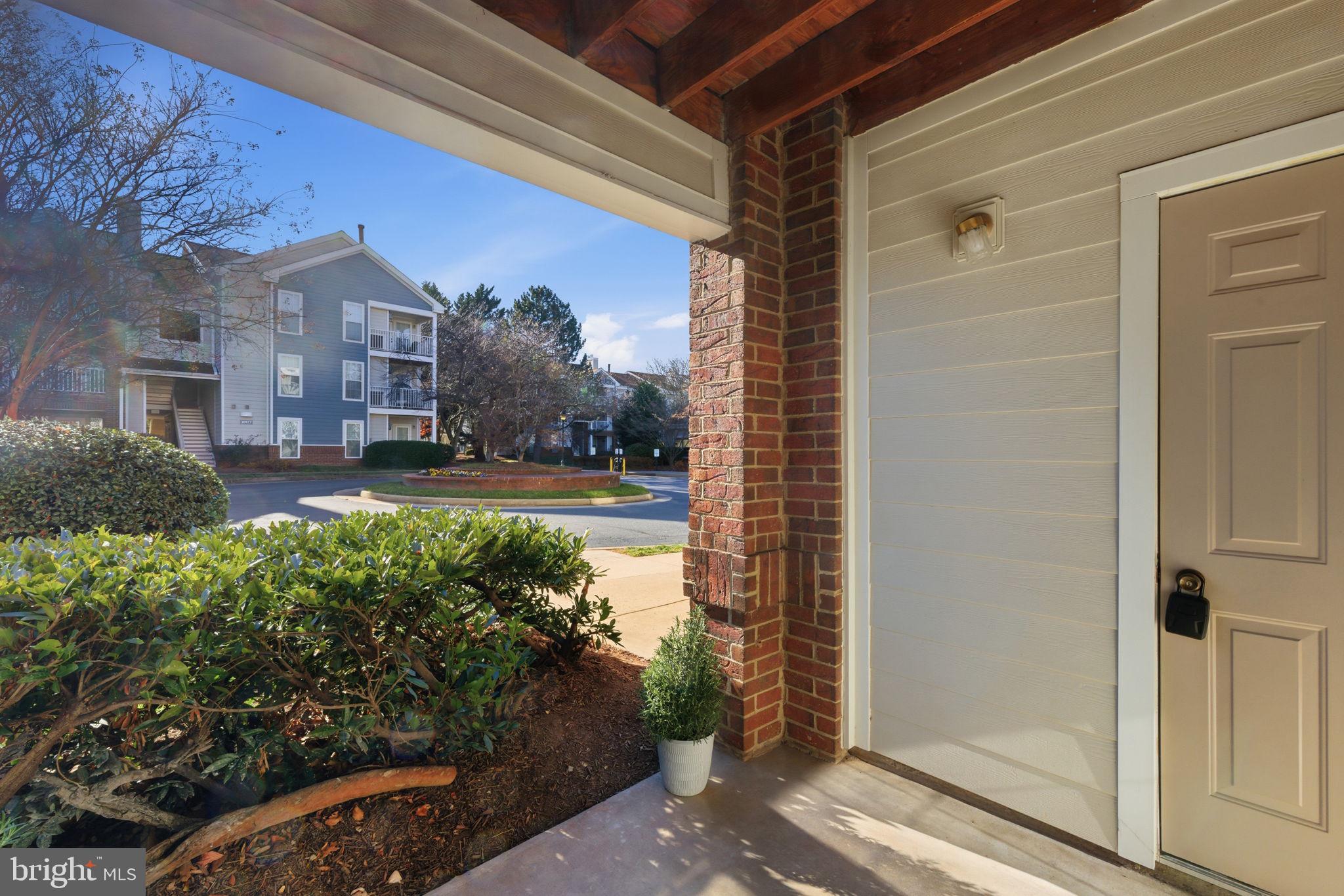 20963 Timber Ridge Terrace, Unit 103 Ashburn, VA 20147 - Photo 18 of 32 a view of a house with a yard and potted plants