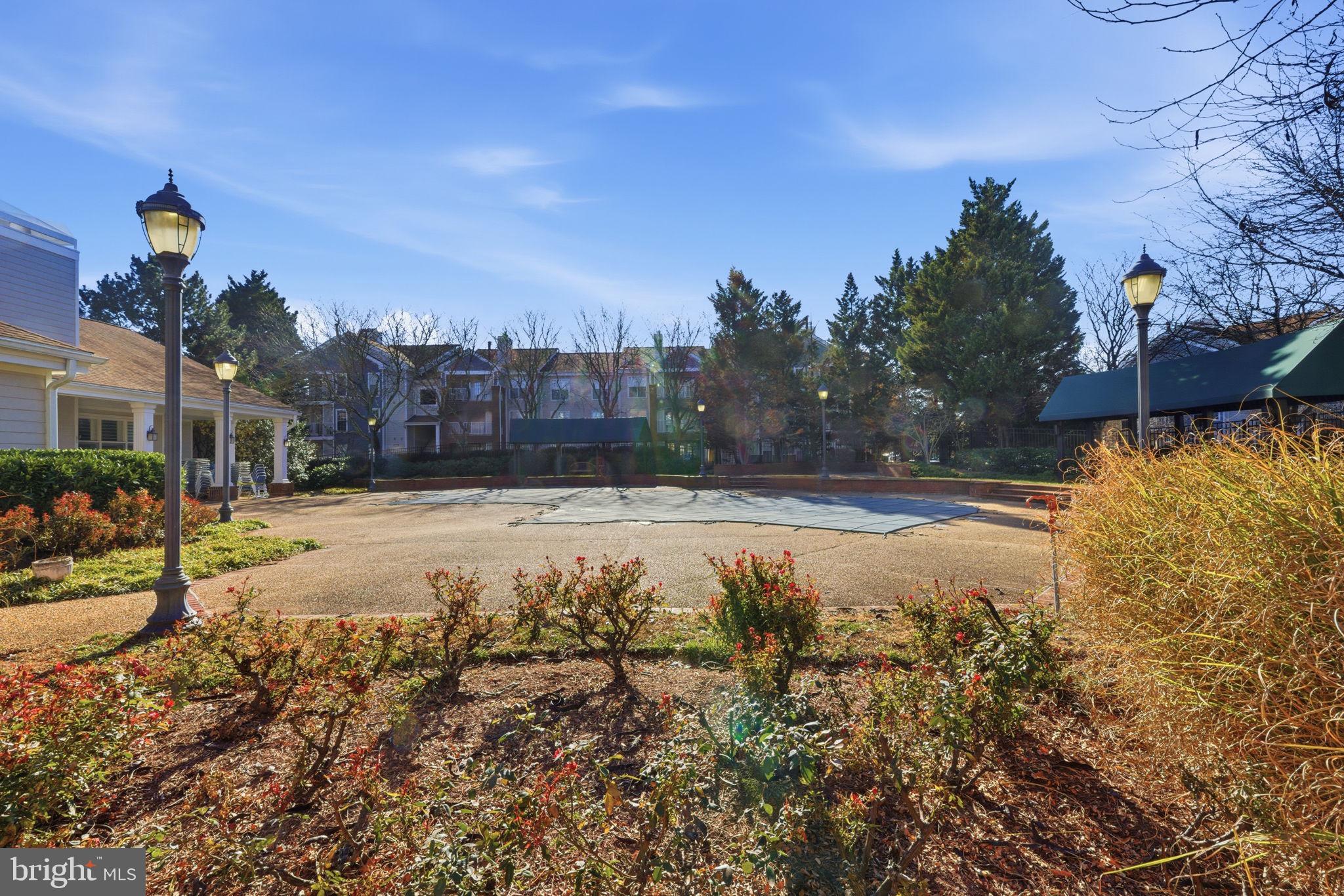 20963 Timber Ridge Terrace, Unit 103 Ashburn, VA 20147 - Photo 19 of 32 a swimming pool with outdoor seating and garden