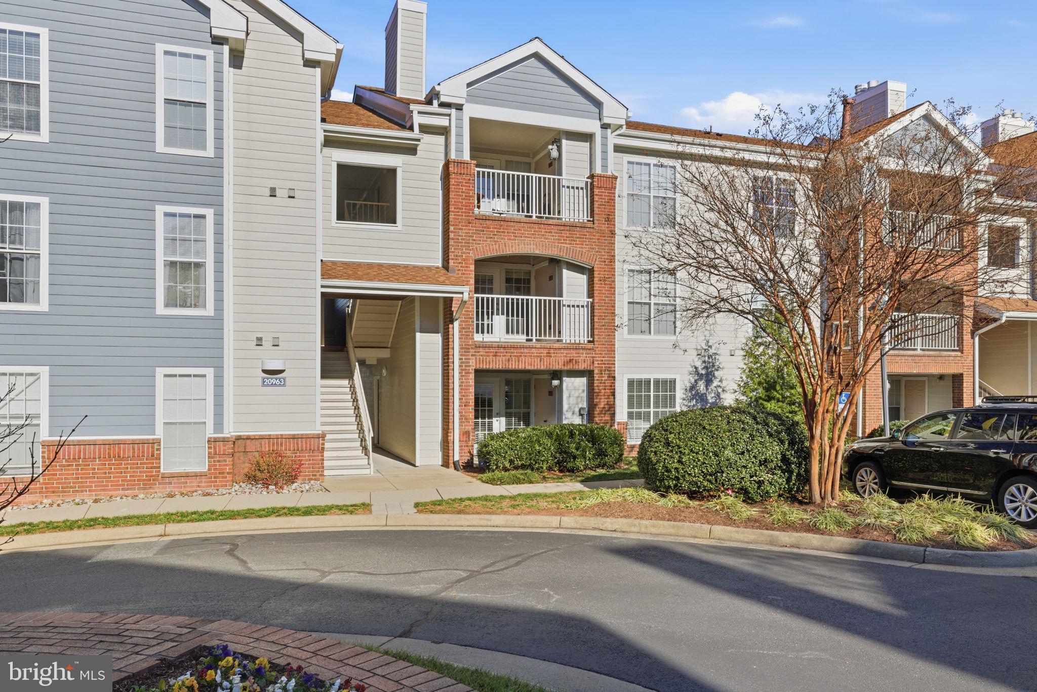 20963 Timber Ridge Terrace, Unit 103 Ashburn, VA 20147 - Photo 2 of 32 a front view of a building with street
