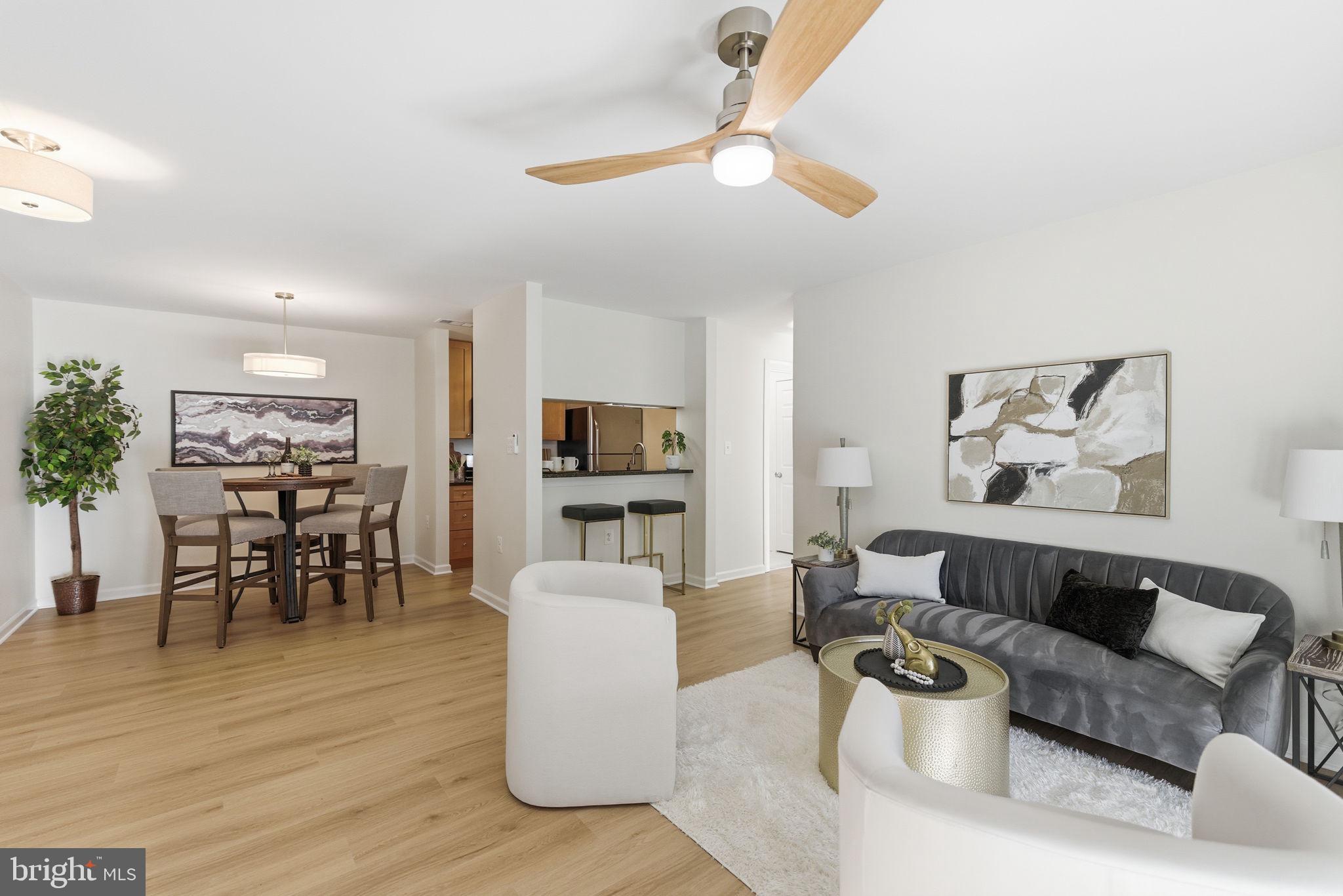 20963 Timber Ridge Terrace, Unit 103 Ashburn, VA 20147 - Photo 5 of 32 a living room with furniture and a wooden floor