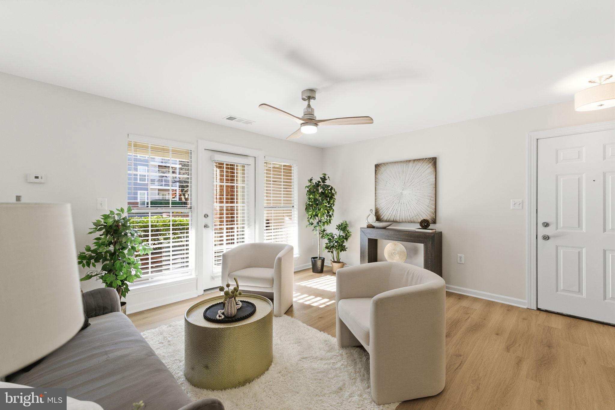 20963 Timber Ridge Terrace, Unit 103 Ashburn, VA 20147 - Photo 7 of 32 a living room with furniture and a floor to ceiling window