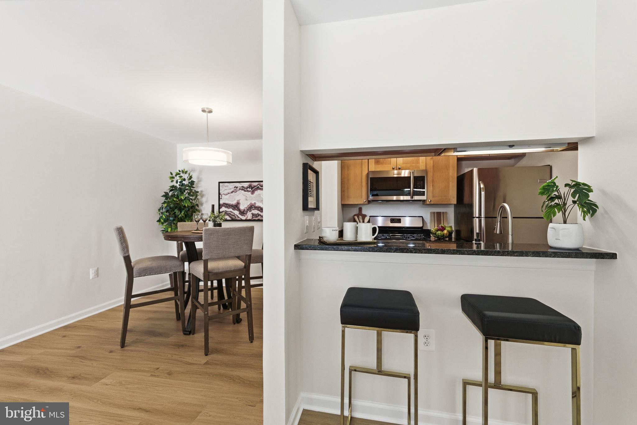 20963 Timber Ridge Terrace, Unit 103 Ashburn, VA 20147 - Photo 8 of 32 a dining room with furniture and wooden floor