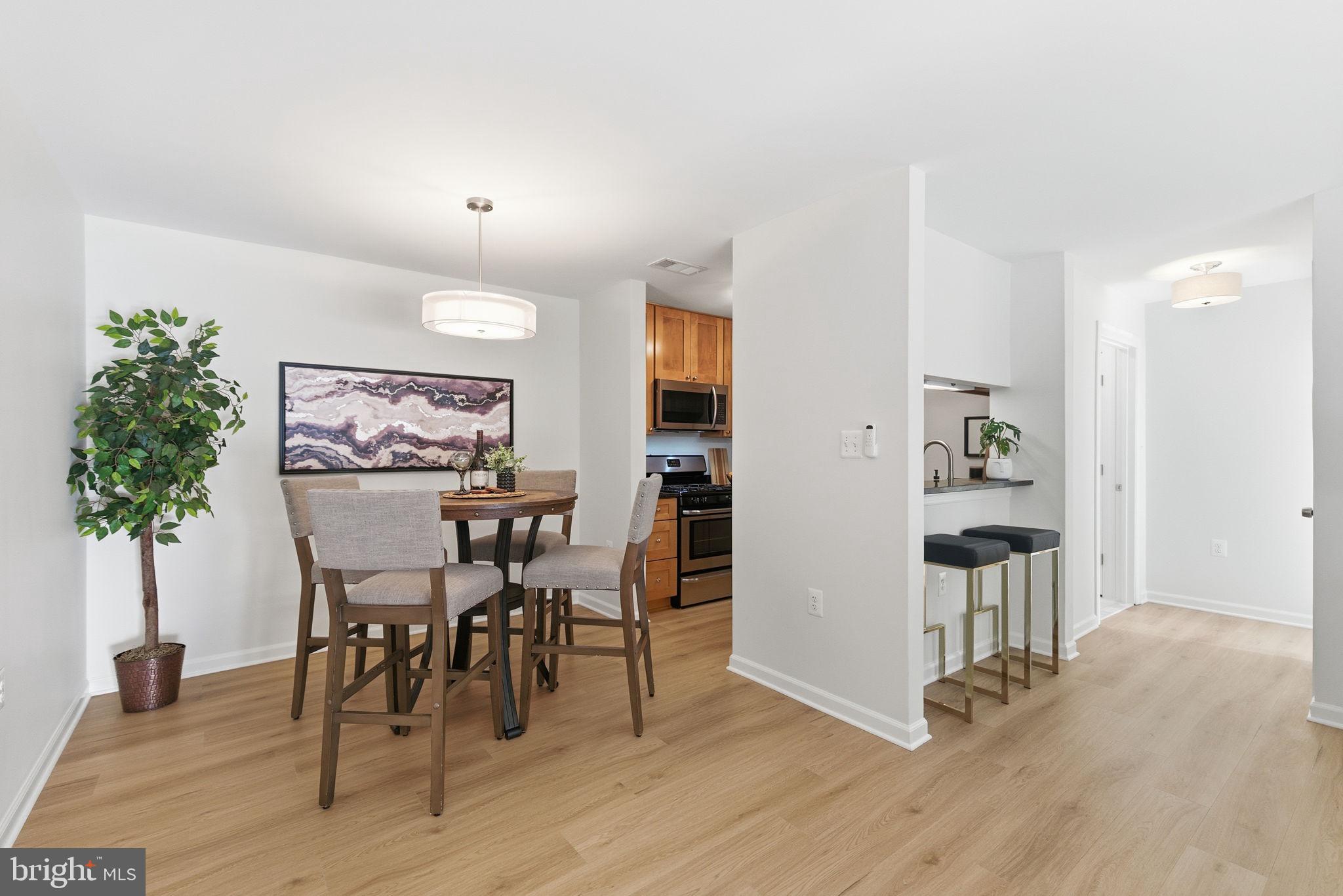 20963 Timber Ridge Terrace, Unit 103 Ashburn, VA 20147 - Photo 9 of 32 a view of a dining room with furniture and wooden floor