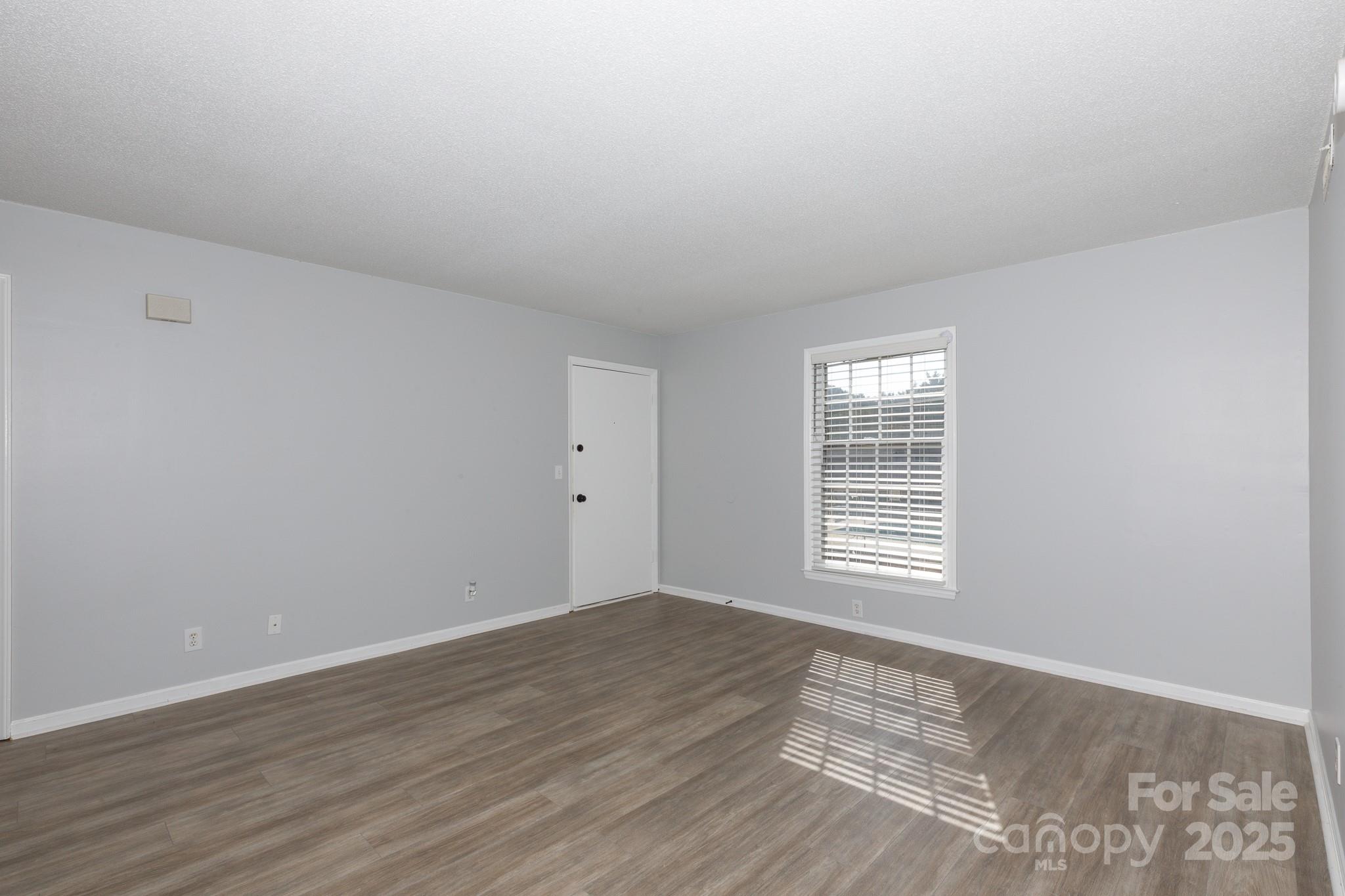 1792 Ebenezer Road, Unit G Rock Hill, SC 29732 - Photo 11 of 28 a view of an empty room with wooden floor and a window