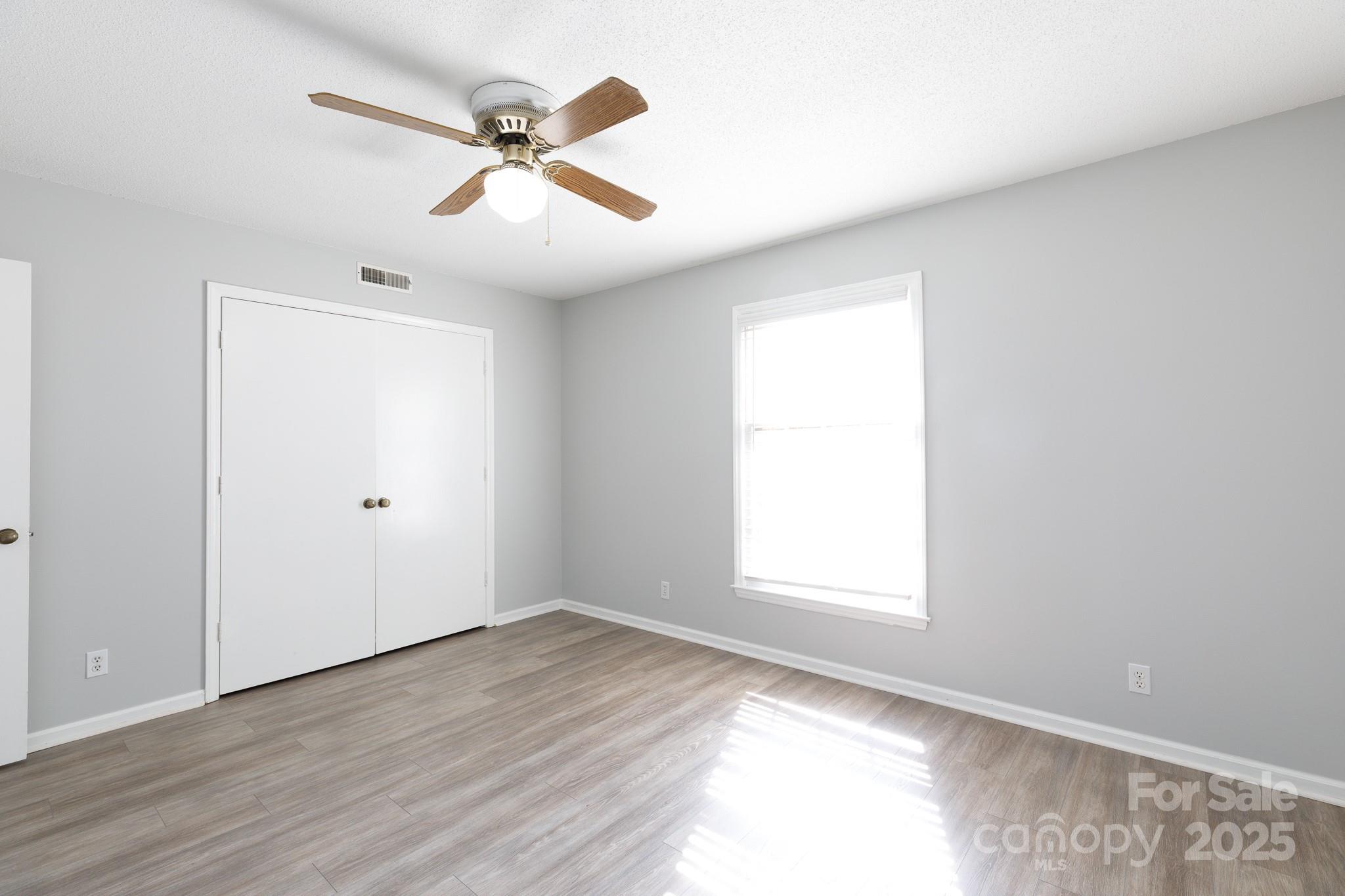 1792 Ebenezer Road, Unit G Rock Hill, SC 29732 - Photo 12 of 28 an empty room with wooden floor ceiling fan and windows