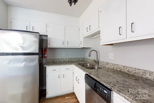 a kitchen with granite countertop white cabinets and white appliances