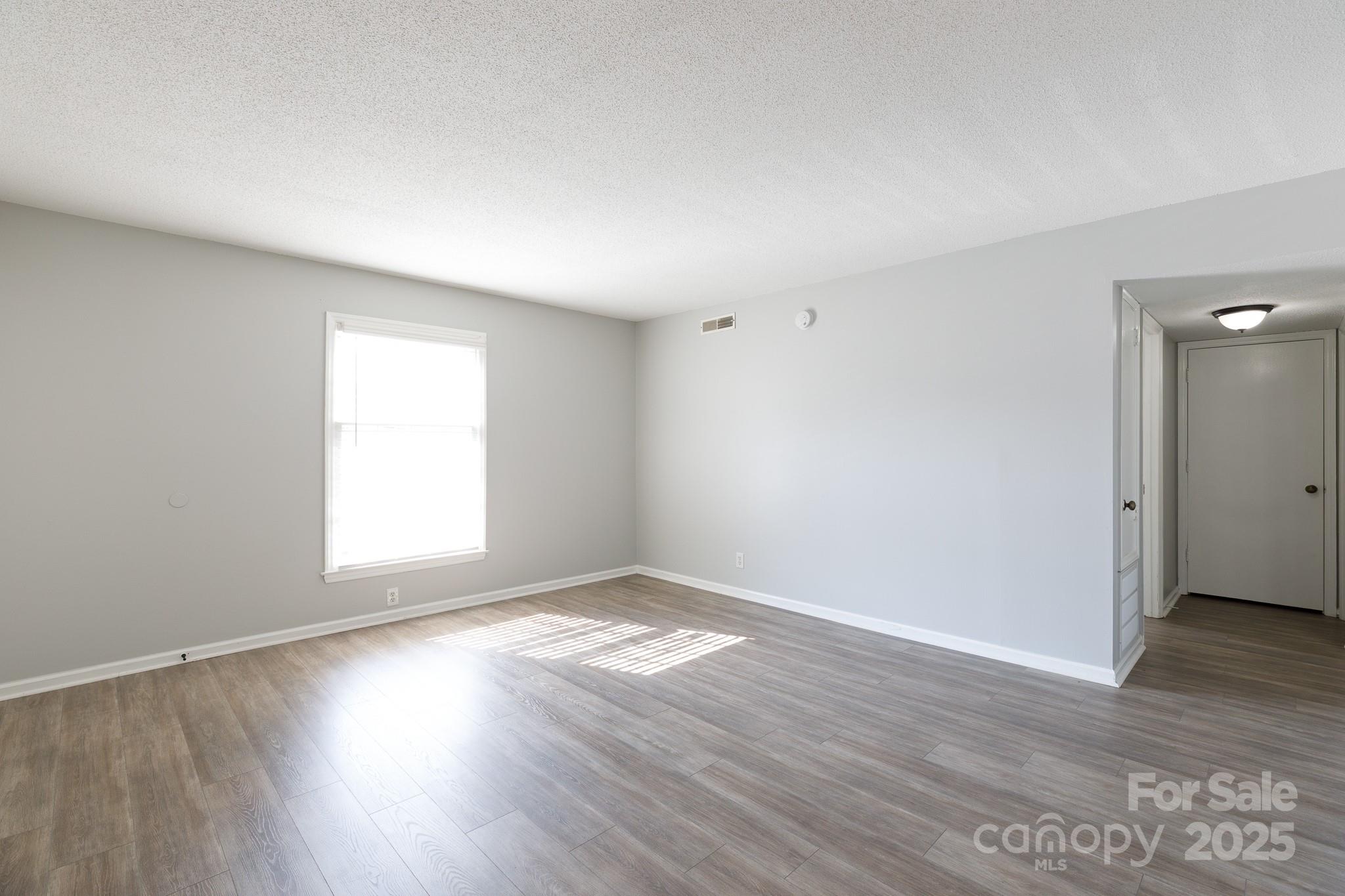 1792 Ebenezer Road, Unit G Rock Hill, SC 29732 - Photo 9 of 28 an empty room with wooden floor and windows