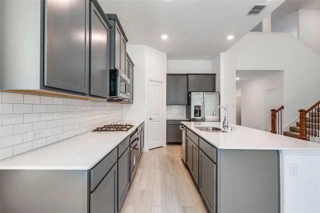 a kitchen with a sink stove and refrigerator