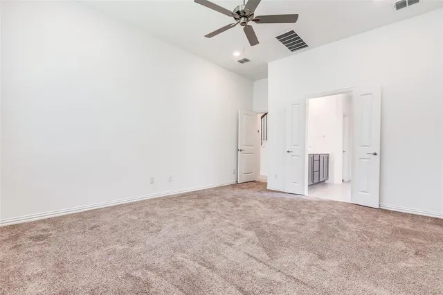 an empty room with fan and windows