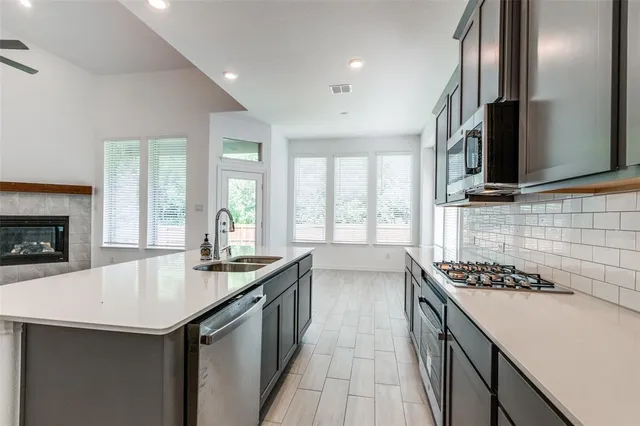 a kitchen with granite countertop a sink stove and cabinets