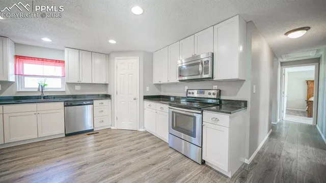 a kitchen with stainless steel appliances granite countertop a stove a sink and a microwave