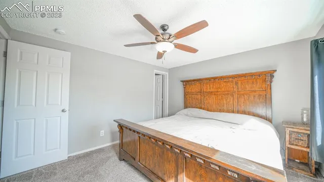 a bedroom with a bed and a ceiling fan
