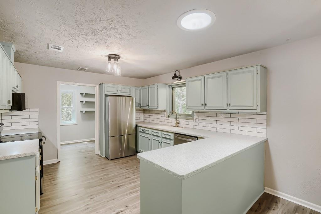 2021 Irwin Bridge Road Northwest Conyers, GA 30012 - Photo 12 of 43 a kitchen with stainless steel appliances granite countertop a refrigerator and a sink