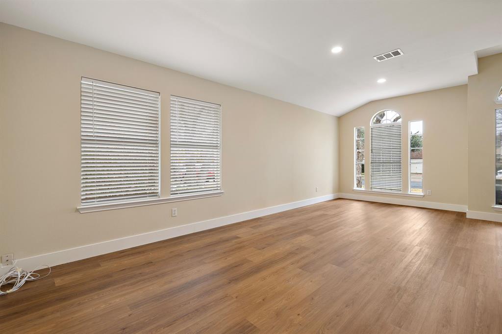 13412 Tossa Lane Austin, TX 78729 - Photo 14 of 16 an empty room with wooden floor and windows